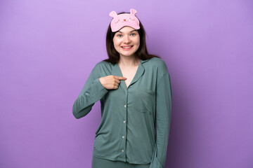 Young Russian woman in pajamas isolated on purple background with surprise facial expression