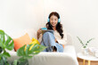 Young smiling woman happy watching movies and  chill relax in summer holiday. Lifestyle girl using laptop for entertainment in living room at home.  Lifestyle Concept