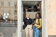 © Maskot - Portrait of young female entrepreneurs with hands in pockets standing at office doorway