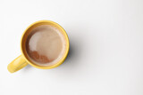 Fototapeta Mapy - Yellow mug of freshly brewed hot coffee on white background, top view. Space for text