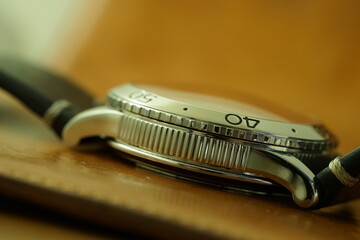 Side view of a steel wristwatch selectively focused on the fluted case and small part of the bezel showing number 40.