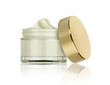 canvas print picture - glass jar of beauty cream with golden lid resting on the side and reflected in the white plane