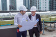 © Washburn - Two experts inspect real estate construction site with civil engineer engineer under checking the industry chilled water fan coil unit air conditioner is water cooling tower air chiller HVAC system of