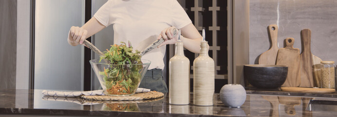 Asian woman making vegetable salad in her home kitchen, Vegetables contain a wide variety of vitamins and minerals, High-fiber and low-calorie diets, Healthy vegetable salad idea, Appetizer concept.