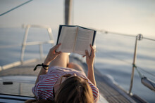 Young Woman Reading A Book On A Boat