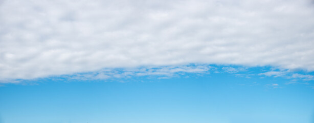 Wall Mural - blue sky background with light grey cloud overcast in the upper half