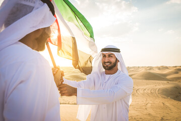 Arabic men in the desert of Dubai wearing traditional emirates clothing