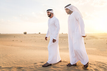 Wall Mural - Arabic men in the desert of Dubai wearing traditional emirates clothing