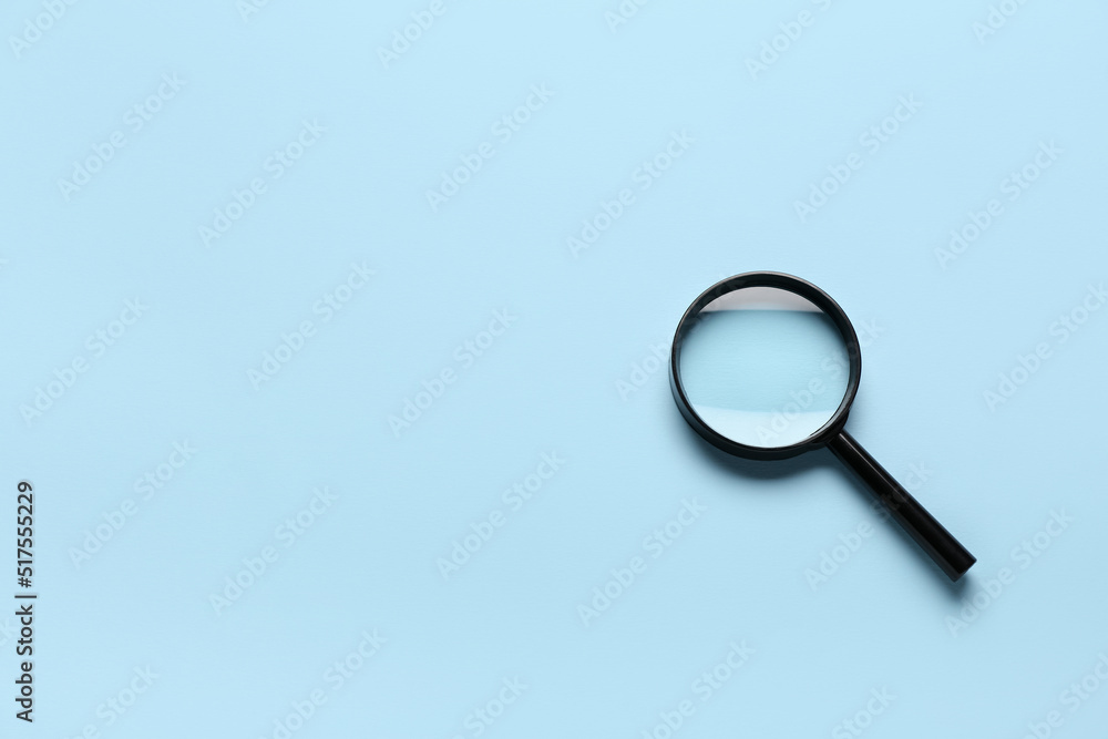 Magnifying glass on light blue background