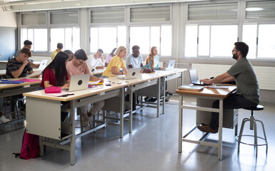 High school class with a male teacher and a group of multi-ethnic students with laptops. Back to school , teaching , education