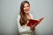 Laughing happy teacher or female student with red book isolated portrait.