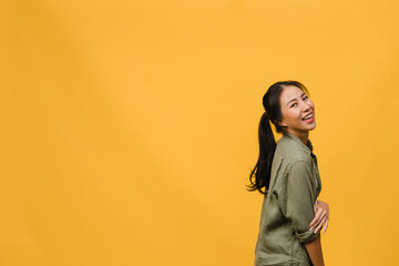 Wall Mural - Portrait of young Asia lady with positive expression, smile broadly, dressed in casual clothing over yellow background. Happy adorable glad woman rejoices success. Facial expression concept.