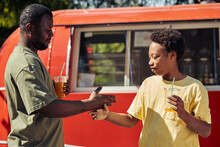 African Father Greeting With His Son By Giving High Five While They Drinking Juice In The Park