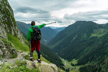 A Man Pointing With Tracking Stick On High Altitude In Mountains