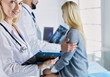 © lenets_tan - Handsome male doctor consulting a couple about infertility in his medical office