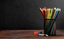 Colorful Pencils On Wooden Table And Blackboard