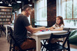 © Przemek Klos - Father playing board game with her daughter in public library. Child spending time with dad after classes at primary school. Positive competition