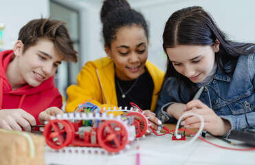 Wall Mural - group of high school students building and programming electric toys and robots at robotics classroo