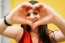Smiling Woman Forming Heart Shape With Hands