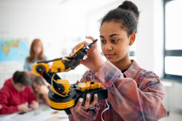 Wall Mural - college student holding her robotic toy at robotics classroom at school.
