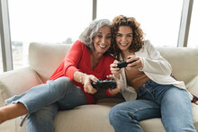 Happy Senior Woman With Friend Playing Video Games