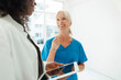 © Westend61 - Smiling nurse talking with female doctor holding tablet PC