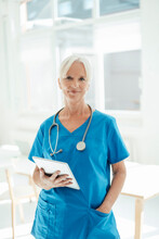 Smiling Female Doctor Holding Tablet PC Standing With Hand In Pocket