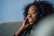 Smiling Young Woman Listening Music Through Wireless Headphones