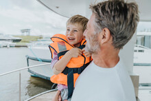 Happy Father Carrying Son In Balcony At Houseboat