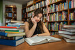 © RomanR - young student after graduation comes to the library to learn new knowledge.