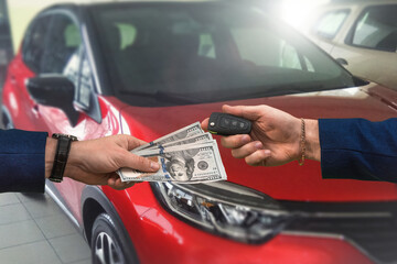 Wall Mural - man hands over a large sum of dollars to another who in return passes the keys to a car bought