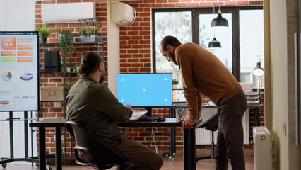 Wall Mural - Team of people using computer with greenscreen and brainstorming ideas to plan startup job. Analyzing blank chroma key monitor display with isolated mockup copyspace and pc background.