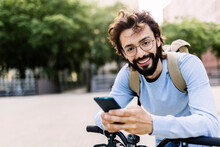 Smiling Man With Bicycle Using Mobile Phone