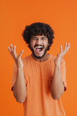 Wall Mural - Portrait of young indian handsome curly shouting man rasing hands