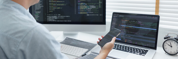 Wall Mural - software development concept, male programmer check website programming on smartphone and computer
