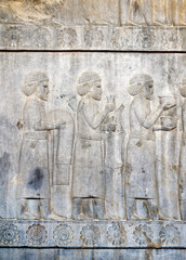 Canvas Print - Ancient wall with bas-relief with assyrian foreign ambassadors with gifts and donations, Persepolis, Iran