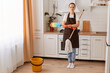 © sementsova321 - Full length portrait of tired housewife washing floor at kitchen, pretty young woman doing home cleanup, keeping her apartment tidy, feeling overworked, looking at camera.
