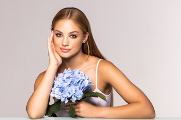 Wall Mural - Beauty face of the young beautiful woman with flower on white background