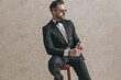 © Viorel Sima - cool fashion stylish man in black tuxedo holding elbow on knee