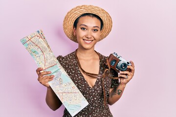 Poster - Beautiful hispanic woman with short hair holding city map and vintage camera smiling with a happy and cool smile on face. showing teeth.