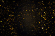 Swirly bokeh of gold glitter shimmer dust shiny particles dark abstract background