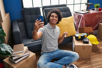 Poster - Young hispanic man make selfie by the smartphone holding key of new house at new home