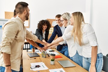 Wall Mural - Group of business workers smiling happy celebrating with hands together at the office.