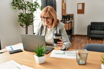 Wall Mural - Middle age businesswoman smiling happy working and drinking coffee at the office.