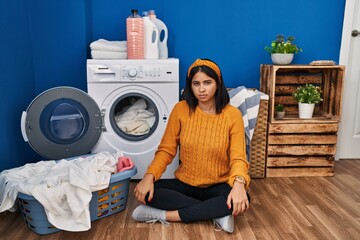 Poster - Young hispanic woman doing laundry skeptic and nervous, frowning upset because of problem. negative person.