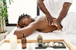 © Krakenimages.com - African american woman reciving back massage at the clinic.