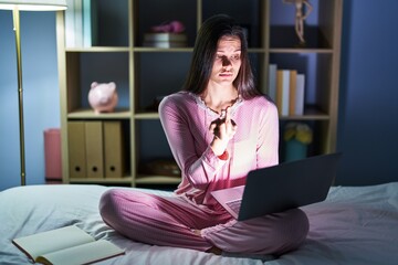 Canvas Print - Young hispanic woman using computer laptop on the bed showing middle finger, impolite and rude fuck off expression