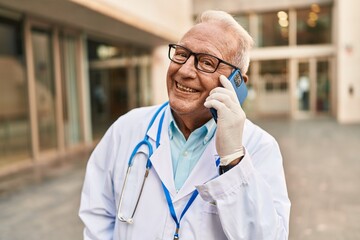 Poster - Senior man wearing doctor uniform talking on the smartphone at street