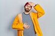 © Krakenimages.com - Caucasian man with beard wearing yellow raincoat touching forehead for illness and fever, flu and cold, virus sick