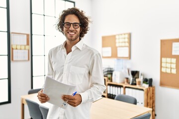 Wall Mural - Young hispanic businessman smiling happy standing at office.